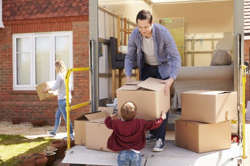 Van and helper loading furniture for a move in Hounslow