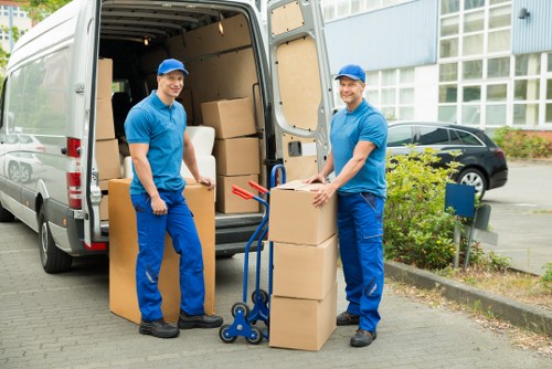 Mover carrying boxes in a Hounslow flat with stair access