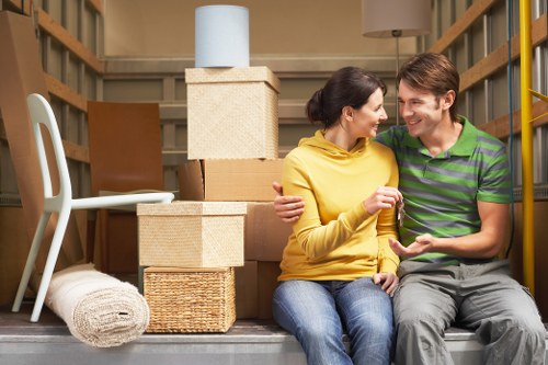 Movers carrying furniture from a Hounslow flat with staircase access